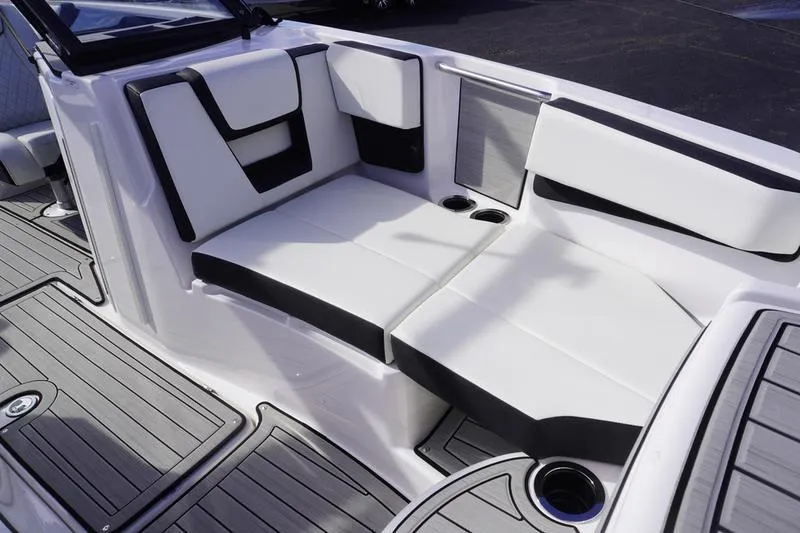 Slide: The Image of 2024 Yamaha Boats 222S interior seating with sleek white and black design, featuring cup holders. - 10