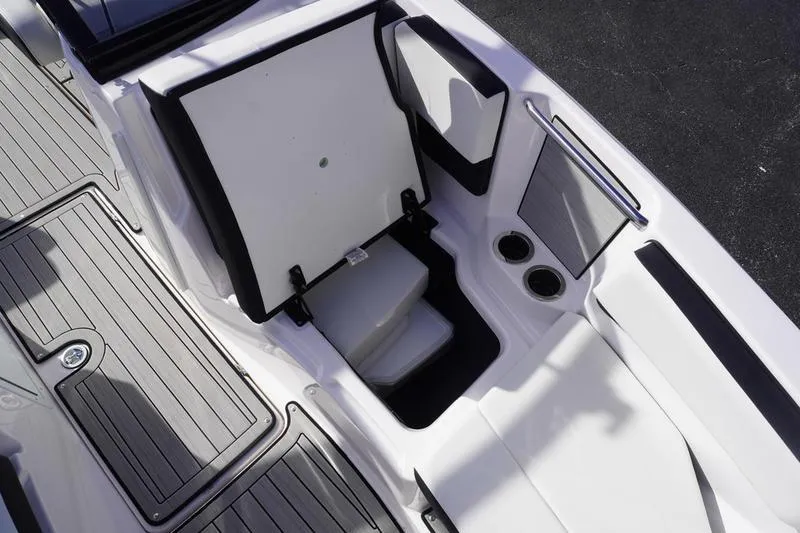 Slide: The Image of 2024 Yamaha Boats 222S interior storage compartment with sleek design and cup holders. - 11