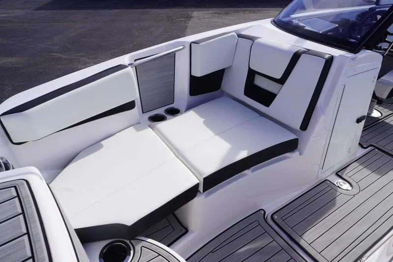 Slide: The Image of 2024 Yamaha Boats 222S interior seating with sleek white and black upholstery. - 13