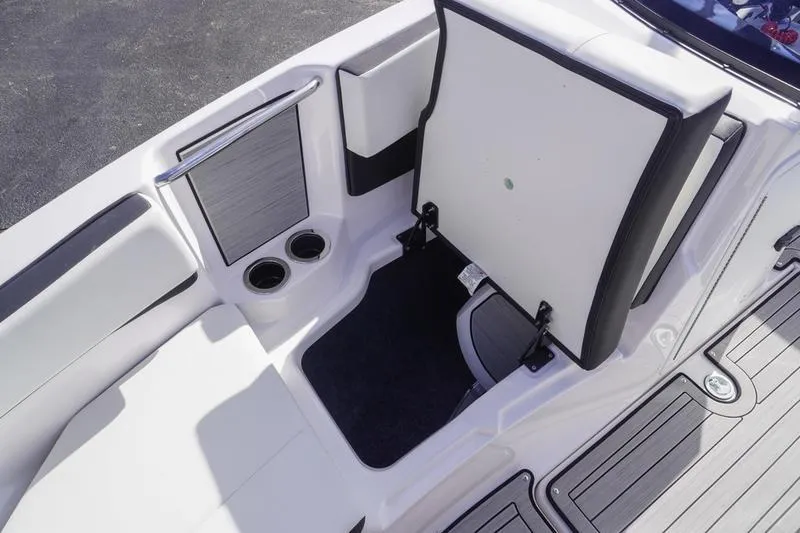 Slide: The Image of 2024 Yamaha Boats 222S interior with open storage compartment and cup holders. - 14
