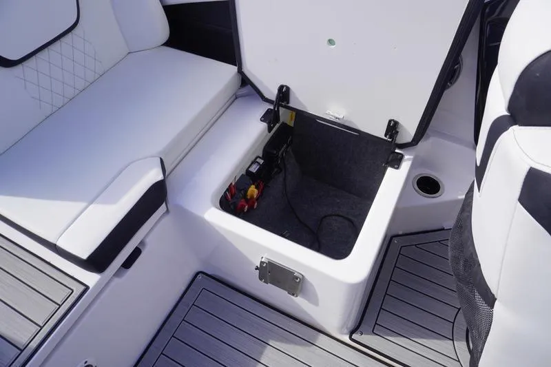 Slide: The Image of 2024 Yamaha Boats 222S storage compartment with open hatch and seating area. - 34