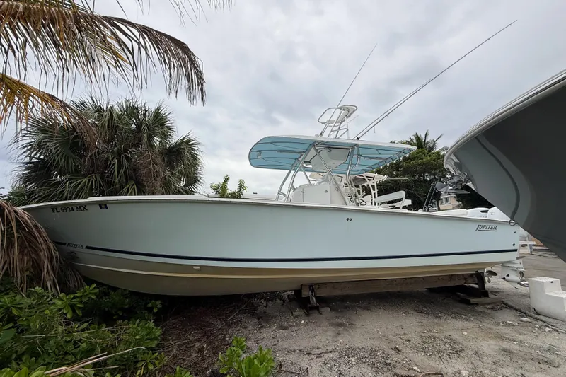 The Image of 2005 Jupiter 31 Center Console boat on dry land, surrounded by palm trees. - 0