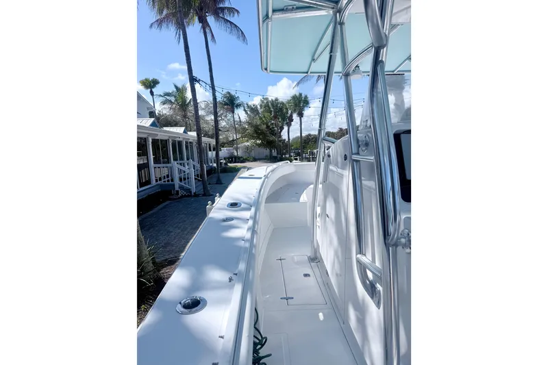 Slide: The Image of 2005 Jupiter 31 Center Console boat docked near palm trees and houses. - 10