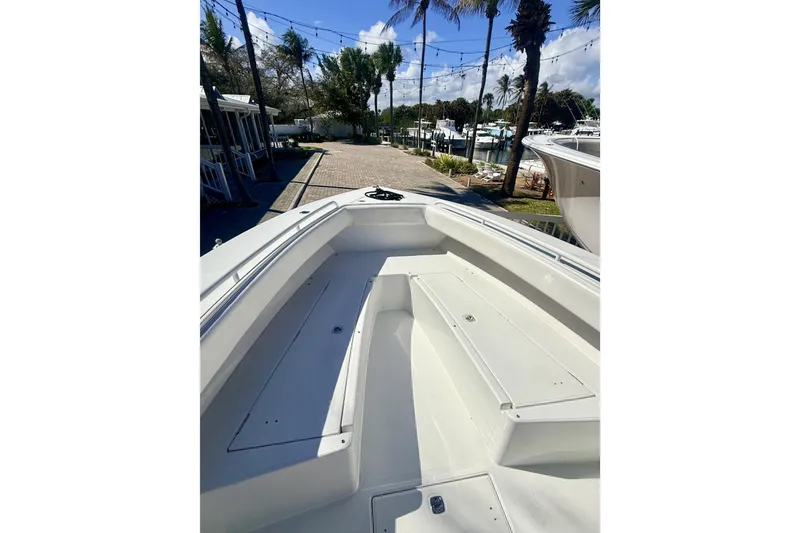 Slide: The Image of 2005 Jupiter 31 Center Console boat deck with seating, docked near palm trees. - 14