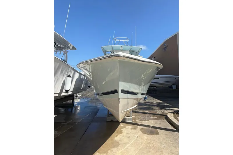 Slide: The Image of 2005 Jupiter 31 Center Console boat in a marina under clear blue sky. - 15
