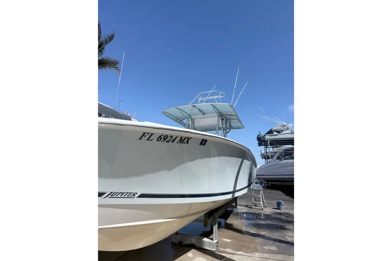 Slide: The Image of 2005 Jupiter 31 Center Console boat on dry dock under clear blue sky. - 17