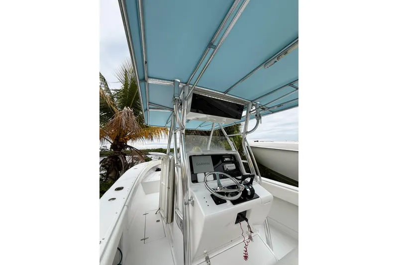 Slide: The Image of 2005 Jupiter 31 Center Console boat with blue canopy and steering console. - 4