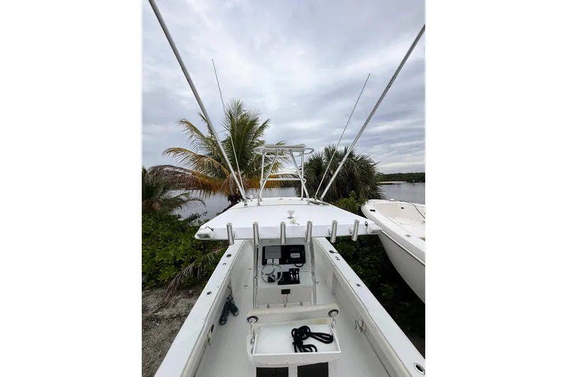 Slide: The Image of 2005 Jupiter 31 Center Console boat docked near palm trees and water. - 6