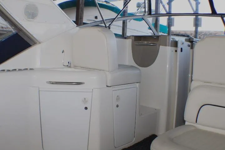Slide: The Image of 2002 Bayliner 3055 Ciera boat interior with white seating and Igloo cooler. - 16