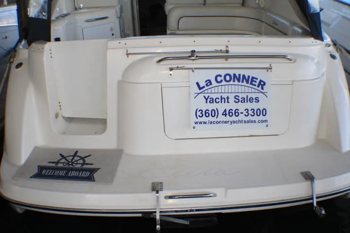 Slide: The Image of 2002 Bayliner 3055 Ciera boat docked in a marina, featuring a sleek white design. - 3