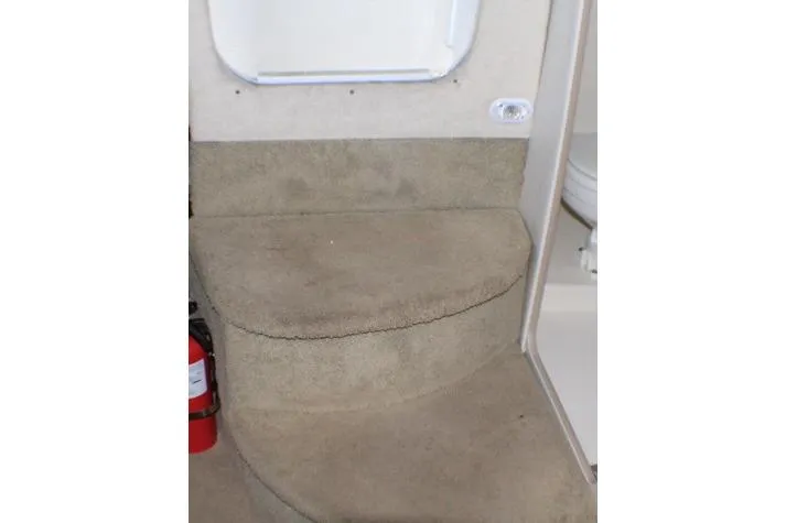 Slide: The Image of Interior view of 2002 Bayliner 3055 Ciera with carpeted flooring and cushioned seating. - 38