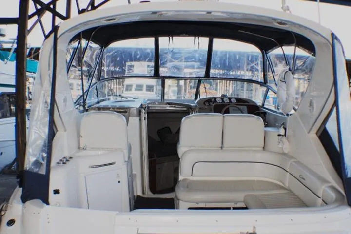 Slide: The Image of 2002 Bayliner 3055 Ciera yacht docked, featuring a covered cockpit and sales sign. - 4