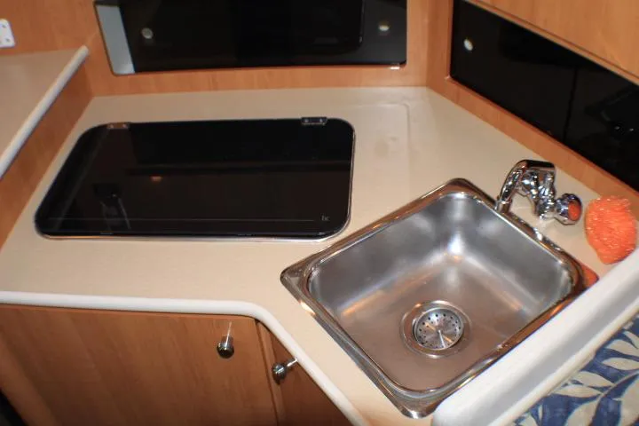 Slide: The Image of Interior view of 2002 Bayliner 3055 Ciera kitchen with microwave, sink, and cabinets. - 43