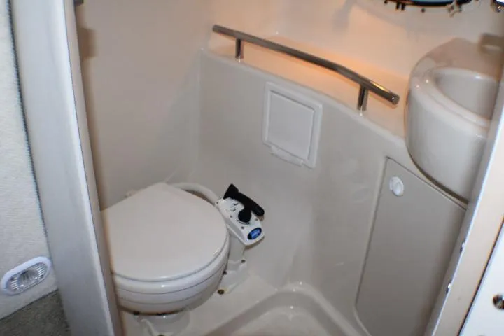 Slide: The Image of 2002 Bayliner 3055 Ciera boat bathroom with toilet, sink, and oval window. - 51