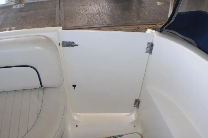 Slide: The Image of 2002 Bayliner 3055 Ciera boat interior with white seating and Igloo cooler. - 9