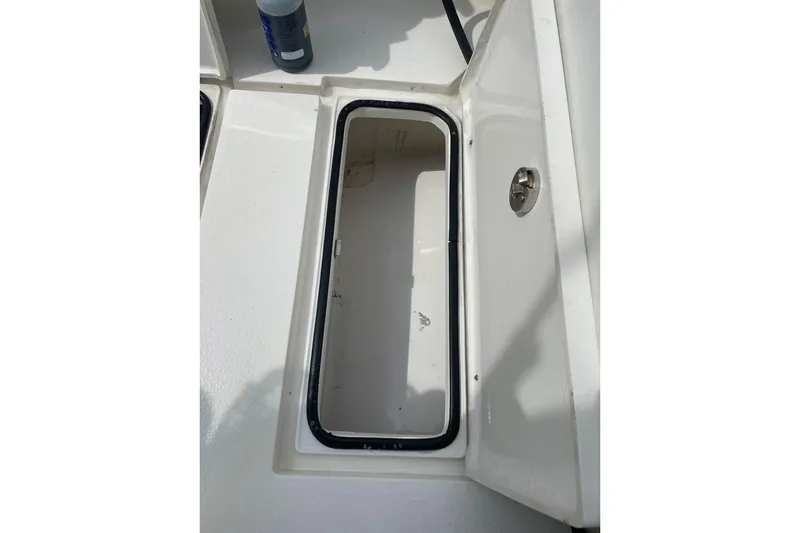 Slide: The Image of Open storage compartment on 2021 Dorado Flatdeck boat, featuring a clean white interior. - 12