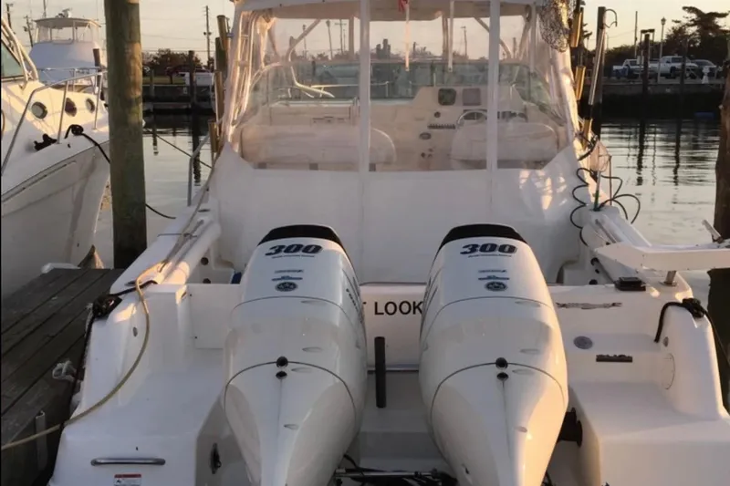 Slide: The Image of 2004 Wellcraft 290 Coastal boat with twin 300 horsepower engines docked at marina. - 2