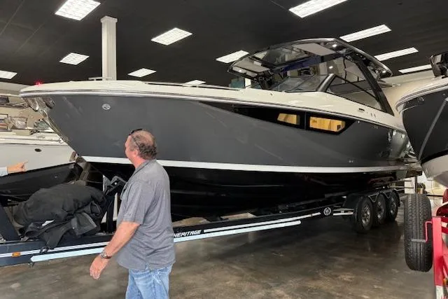 The Image of 2025 Cobalt R35 boat on trailer in showroom with person observing. - 0