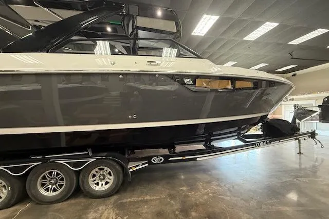 Slide: The Image of 2025 Cobalt R35 boat on trailer in showroom, sleek black and white design. - 11