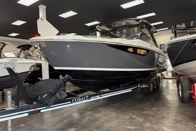 Slide: The Image of 2025 Cobalt R35 boat on trailer in showroom, sleek design, black and white exterior. - 12