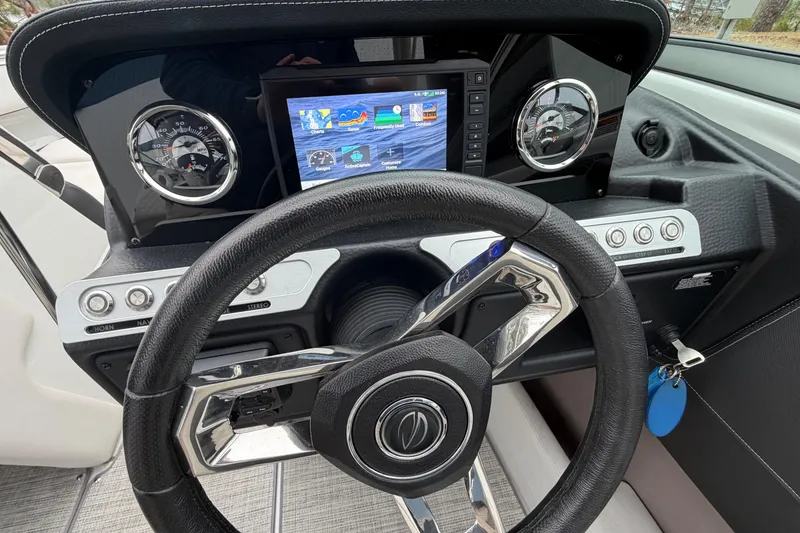 Slide: The Image of 2022 Crownline 240 SS dashboard with steering wheel and digital display. - 12