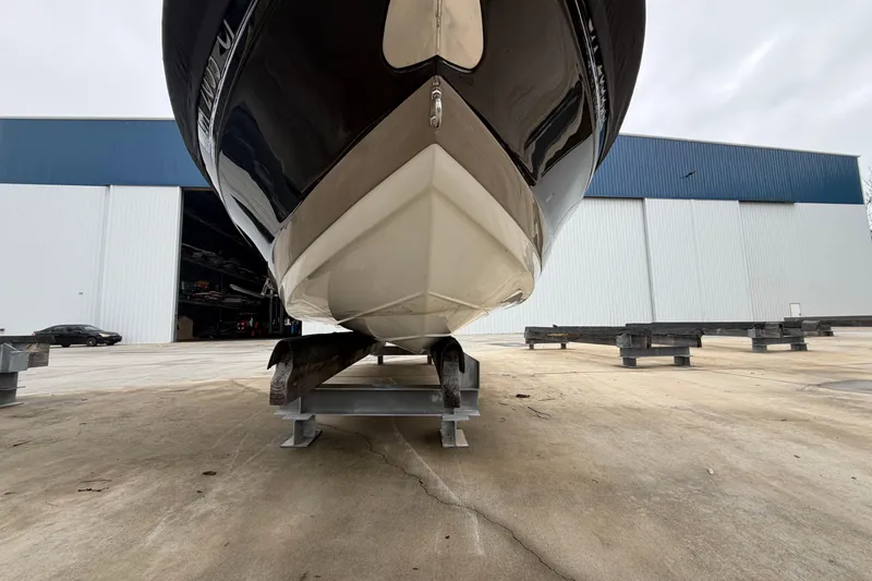 Slide: The Image of 2022 Crownline 240 SS boat on dry dock near large warehouse. - 17