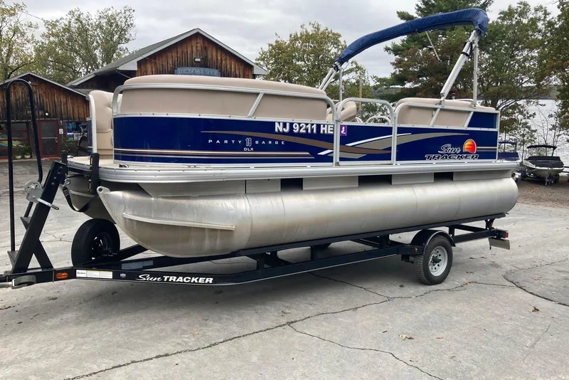 The Image of 2014 Sun Tracker Party Barge 18 DLX pontoon boat on trailer, parked outdoors. - 0