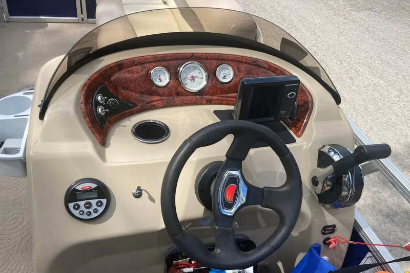 Slide: The Image of 2014 Sun Tracker Party Barge 18 DLX dashboard with steering wheel and control panel. - 6