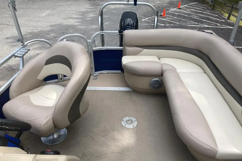 Slide: The Image of 2014 Sun Tracker Party Barge 18 DLX interior with beige seating and steering console. - 7