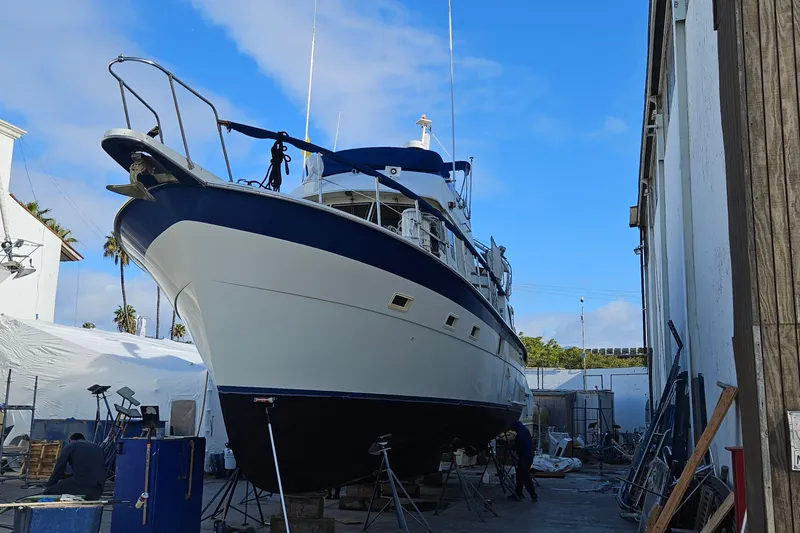 Slide: The Image of 1976 Hatteras 48 Long Range Cruiser docked in a marina with American flag. - 27