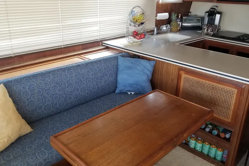 Slide: The Image of 1976 Hatteras 48 Long Range Cruiser docked, featuring blue accents and stainless steel railings. - 36