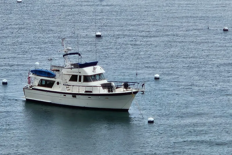 Slide: The Image of 1976 Hatteras 48 Long Range Cruiser yacht docked in a marina, clear blue sky. - 4