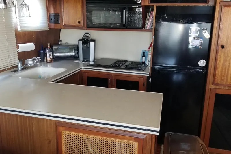 Slide: The Image of Interior of 1976 Hatteras 48 Long Range Cruiser with blue sofa, TV, and fishing rods. - 46