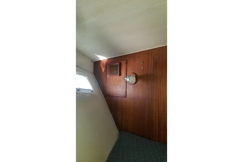 Slide: The Image of 1976 Hatteras 48 Long Range Cruiser on calm water, marina in background. - 78