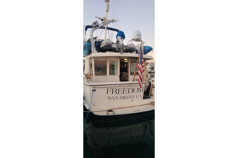 Slide: The Image of Inflatable dinghy on 1976 Hatteras 48 Long Range Cruiser, docked by the water. - 8