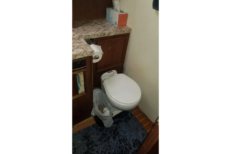 Slide: The Image of 1976 Hatteras 48 Long Range Cruiser on calm water, marina in background. - 81