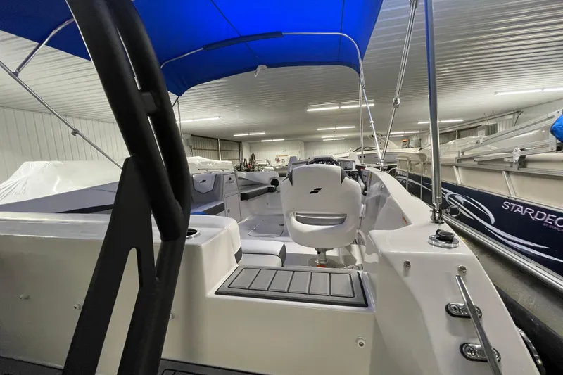 Slide: The Image of 2026 Starcraft SVX 191 OB boat interior with blue canopy in a showroom. - 18