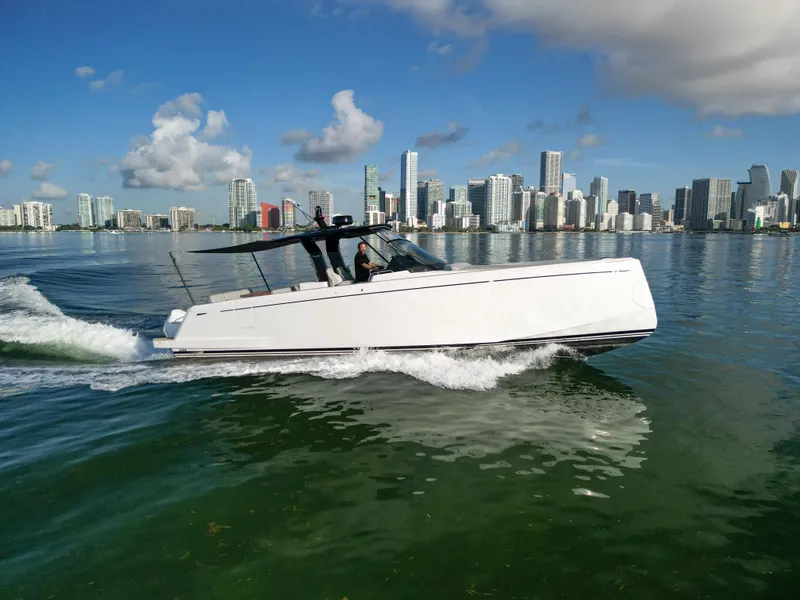 Slide: The Image of 2022 Pardo Yachts 38 cruising on water with city skyline in background. - 2