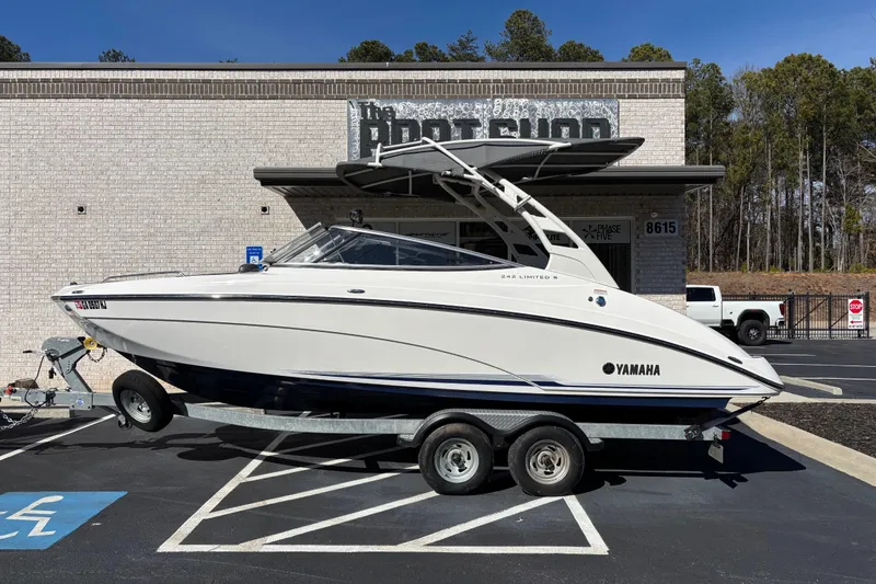 The Image of 2017 Yamaha 242 Limited SE-Series boat on trailer, parked outside a shop. - 1
