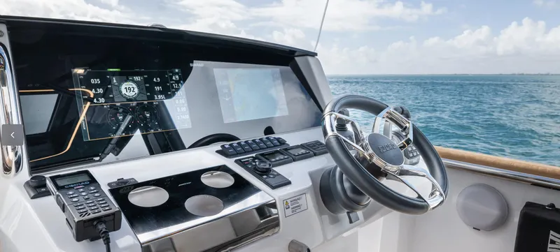Slide: The Image of 2023 Fjord 38 boat cockpit with modern navigation system and steering wheel, ocean view. - 19