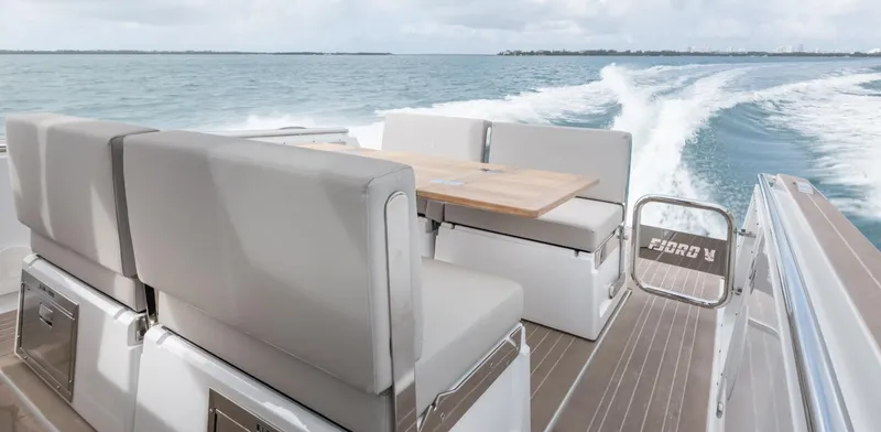 Slide: The Image of 2023 Fjord 38 boat interior with seating and table on open water. - 25
