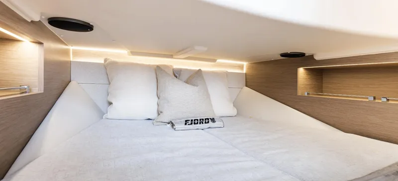 Slide: The Image of 2023 Fjord 38 interior cabin with cozy bedding and modern lighting. - 28