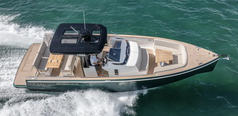 Slide: The Image of 2023 Fjord 38 boat cruising on open water, showcasing sleek design and spacious deck. - 6