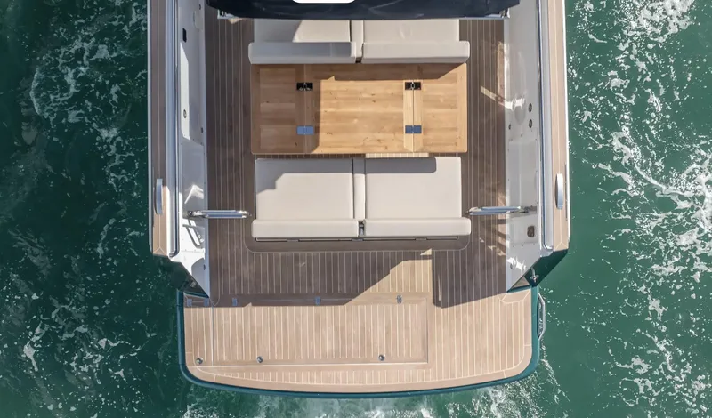 Slide: The Image of 2023 Fjord 38 yacht deck with seating and table, surrounded by ocean water. - 9