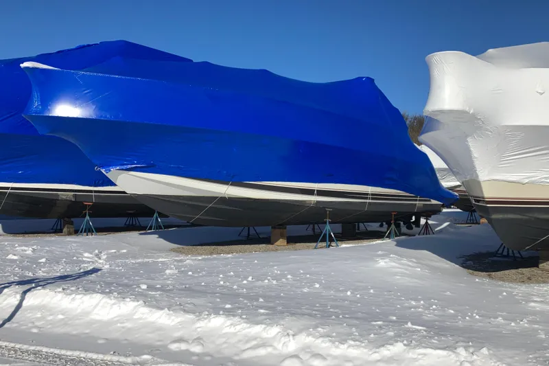Slide: The Image of 2001 Formula 37 Performance Cruiser boats covered in blue and white tarps, winter storage. - 67