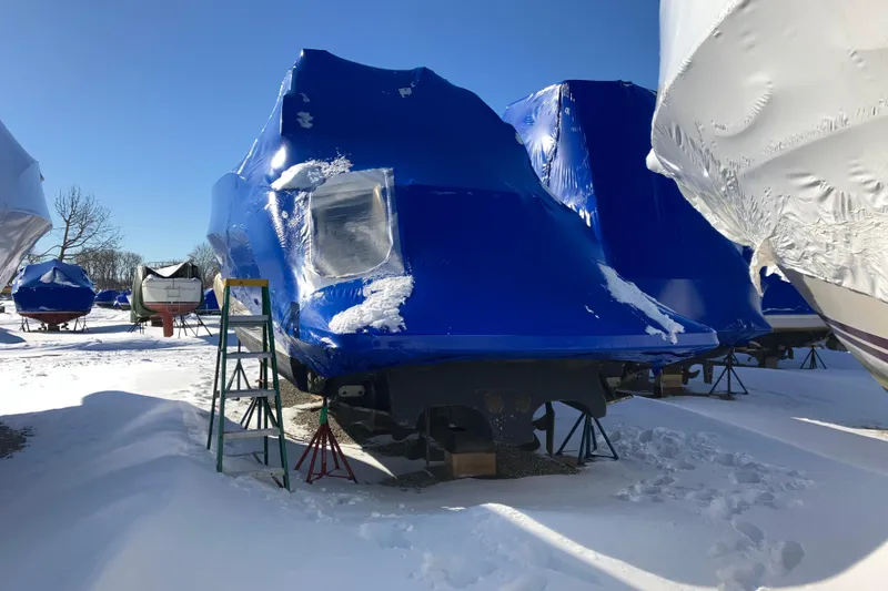 Slide: The Image of 2001 Formula 37 Performance Cruiser covered in blue tarp, stored outdoors in snowy conditions. - 65