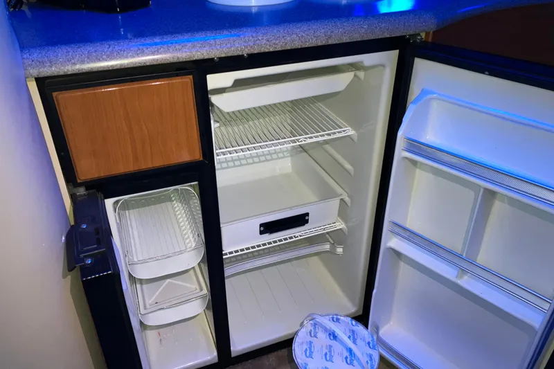 Slide: The Image of Open refrigerator inside a 2001 Formula 37 Performance Cruiser, featuring shelves and storage compartments. - 20