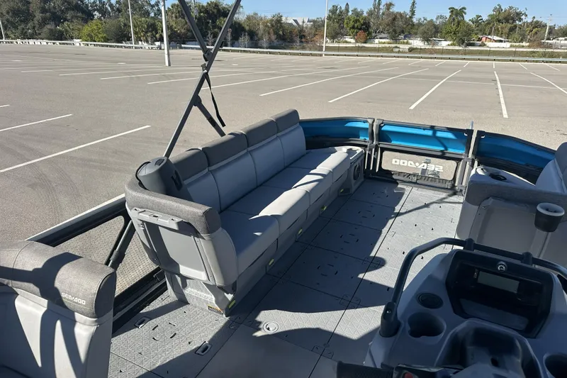 Slide: The Image of 2022 Sea-Doo Switch Sport 21 pontoon boat interior with spacious seating in a parking lot. - 13