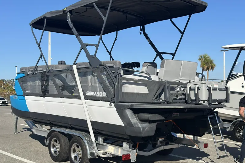 Slide: The Image of 2022 Sea-Doo Switch Sport 21 on trailer, parked outdoors under clear sky. - 3