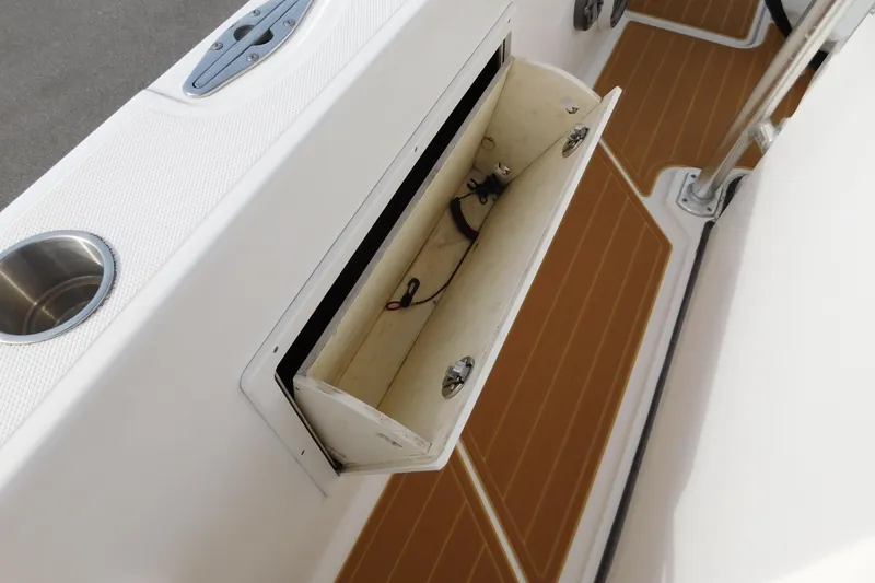 Slide: The Image of 2008 Wellcraft 27 Scarab Tournament boat storage compartment with open hatch and cup holder. - 50